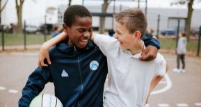 Twee vriendjes zijn buiten aan het basketballen
