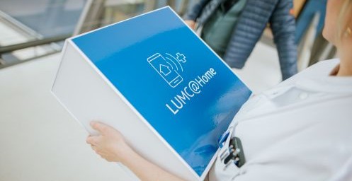 Cardioloog met een LUMC@HOME doos in haar handen