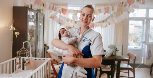 Kraamverzorgende Julia Meulstee met een pasgeboren baby in haar hand
