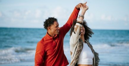 Vrolijk koppel danst op het strand