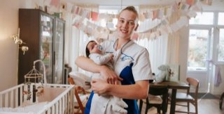 Kraamverzorgende Julia Meulstee met een pasgeboren baby in haar hand