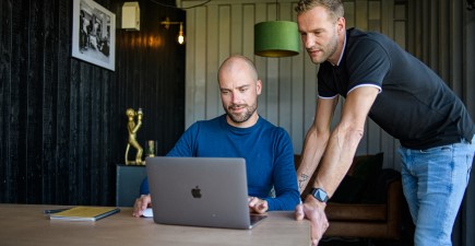 Twee mannen achter een laptop